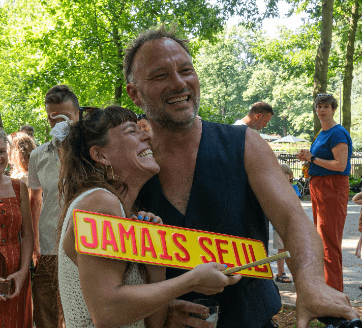 Jef en Lotte lachen met het Jamais Seul bord.